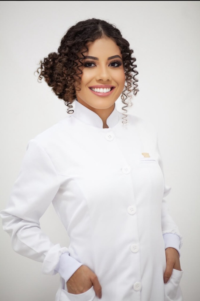 Valeria Rhibeiro de jaleco branco, atendimento de Estética Integrativa